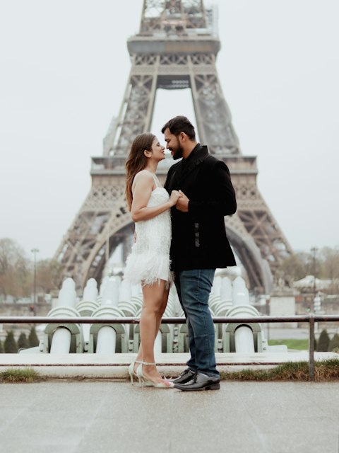 Casal abraçado diante da Torre Eiffel, em Paris
