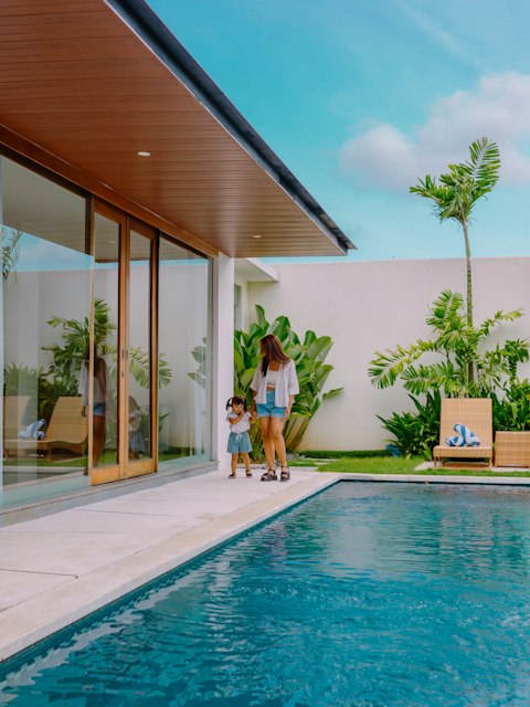 Mãe e filho à beira da piscina de um resort